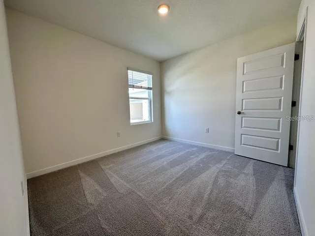 an empty room with windows and closet