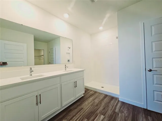 a spacious bathroom with a double vanity sink and mirror