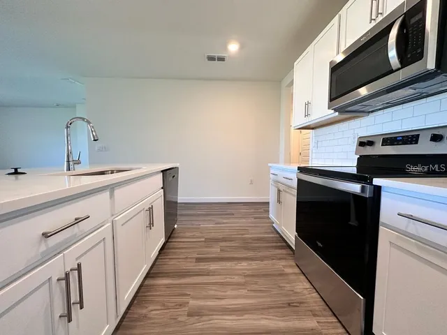 a kitchen with stainless steel appliances a stove microwave and cabinets
