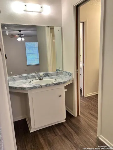a bathroom with a granite countertop sink and a mirror