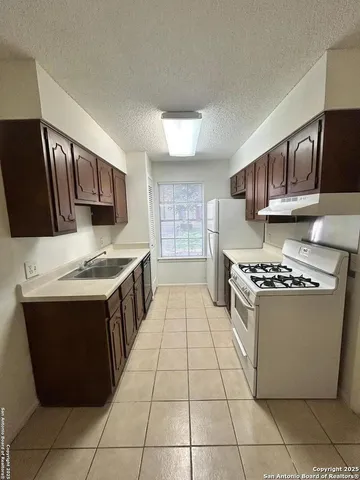 a kitchen with stainless steel appliances granite countertop a stove a sink dishwasher and a refrigerator
