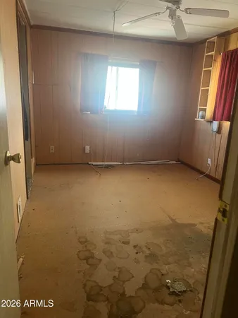 an empty room with windows and fireplace