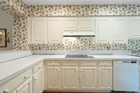a kitchen with white cabinets and sink