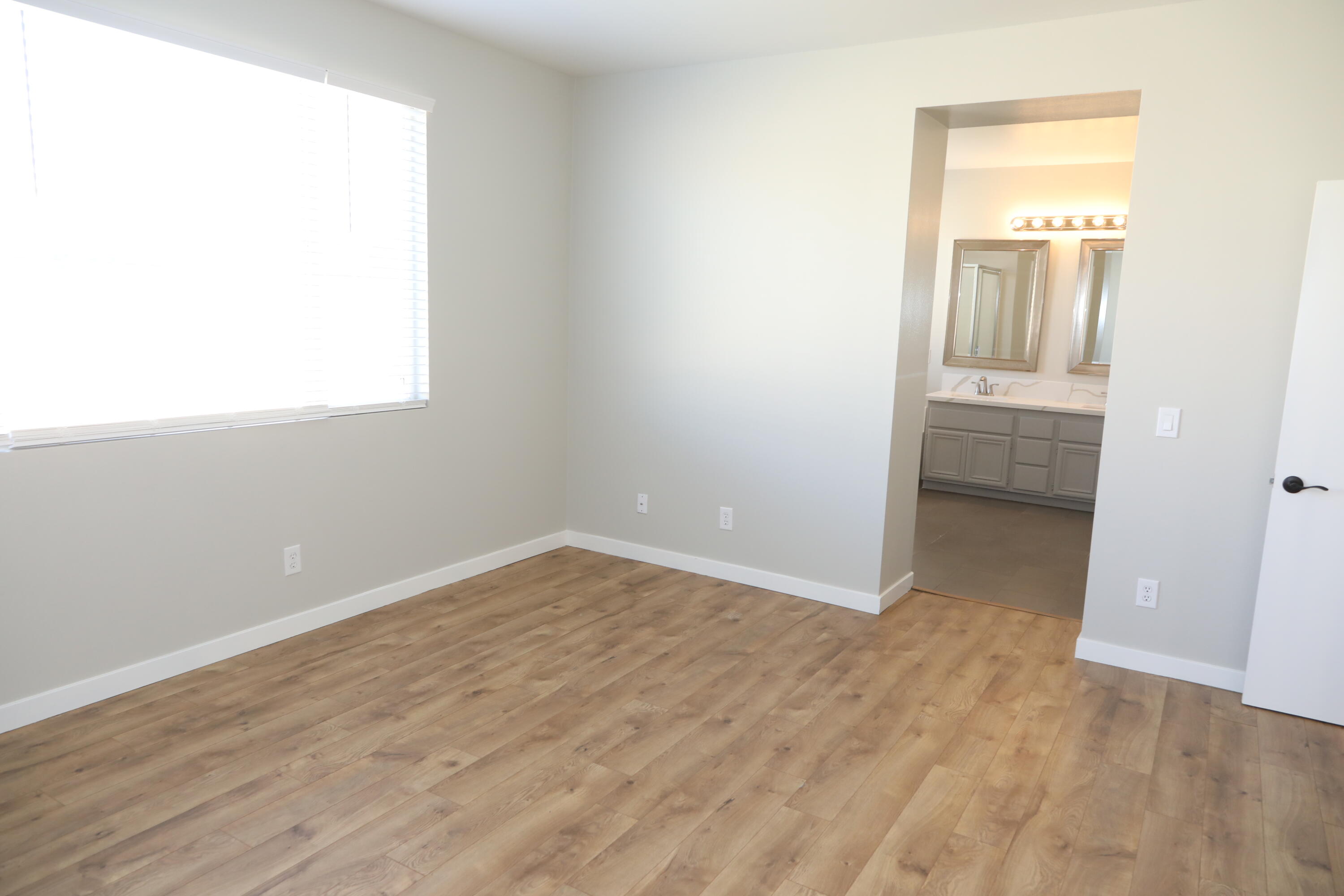 1559 Ave H4 Lancaster, CA 93534 - Photo 14 of 16 a view of an empty room with wooden floor and a window