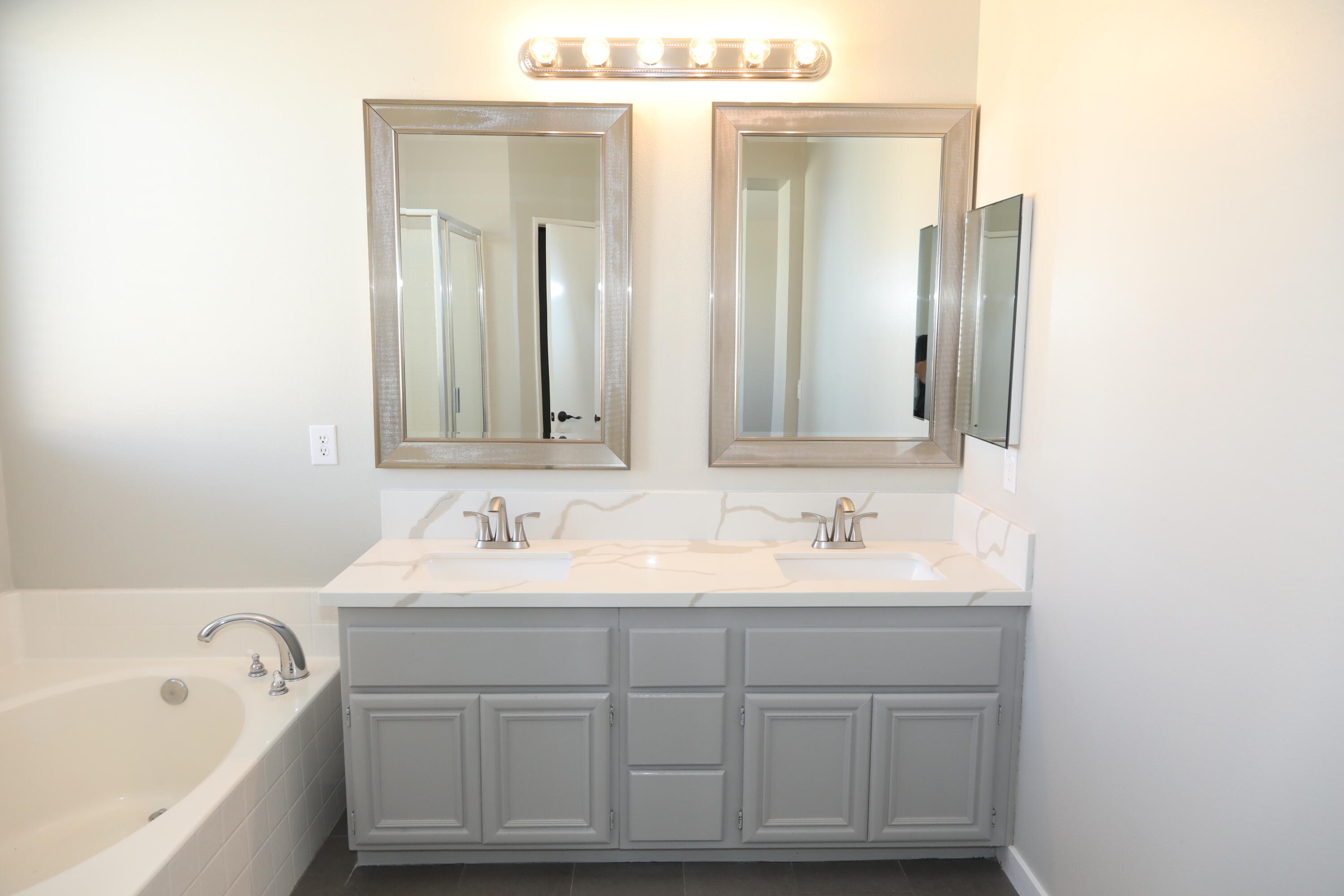 1559 Ave H4 Lancaster, CA 93534 - Photo 15 of 16 a bathroom with a double vanity sink mirror and bathtub