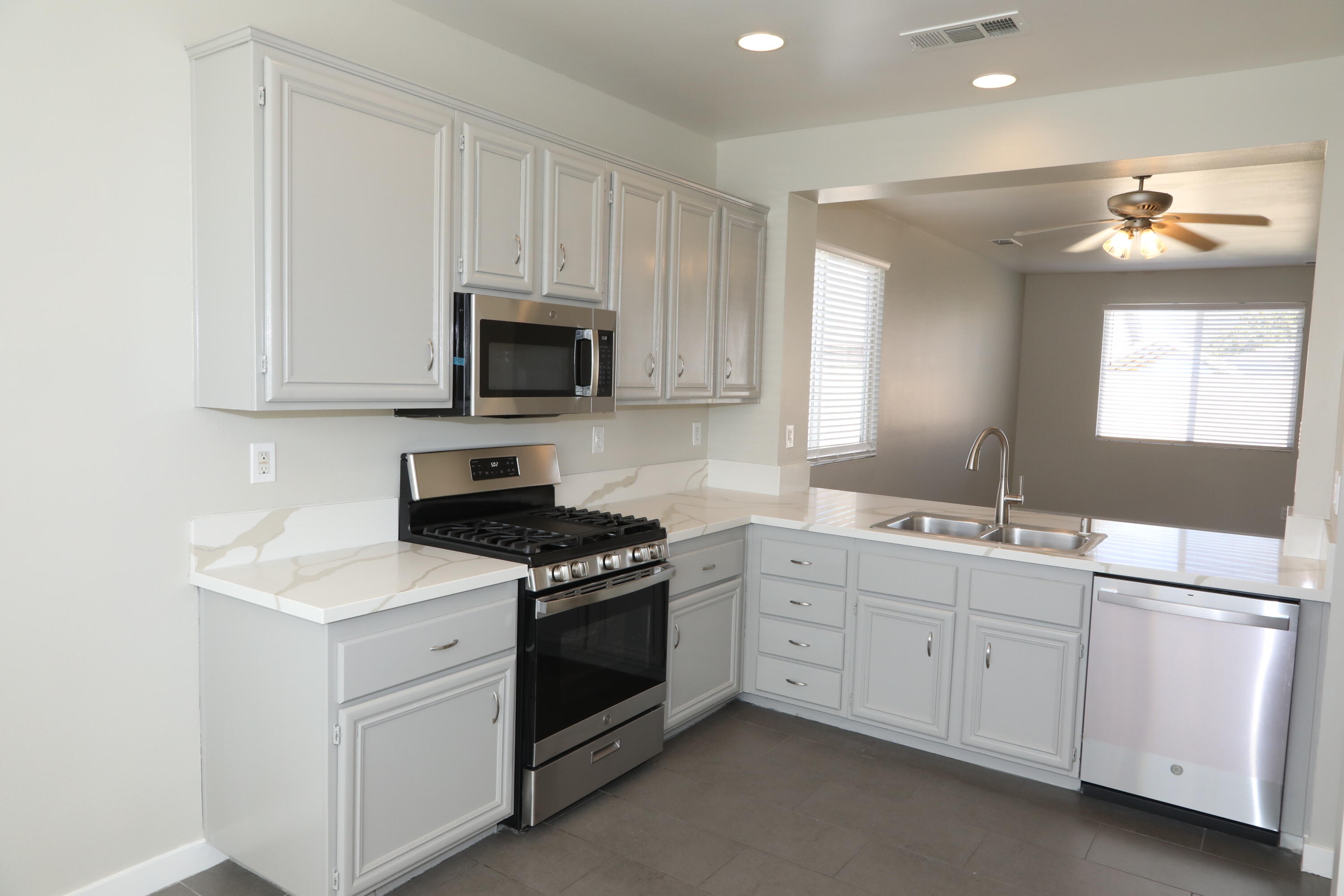 1559 Ave H4 Lancaster, CA 93534 - Photo 2 of 16 a kitchen with white cabinets and white appliances
