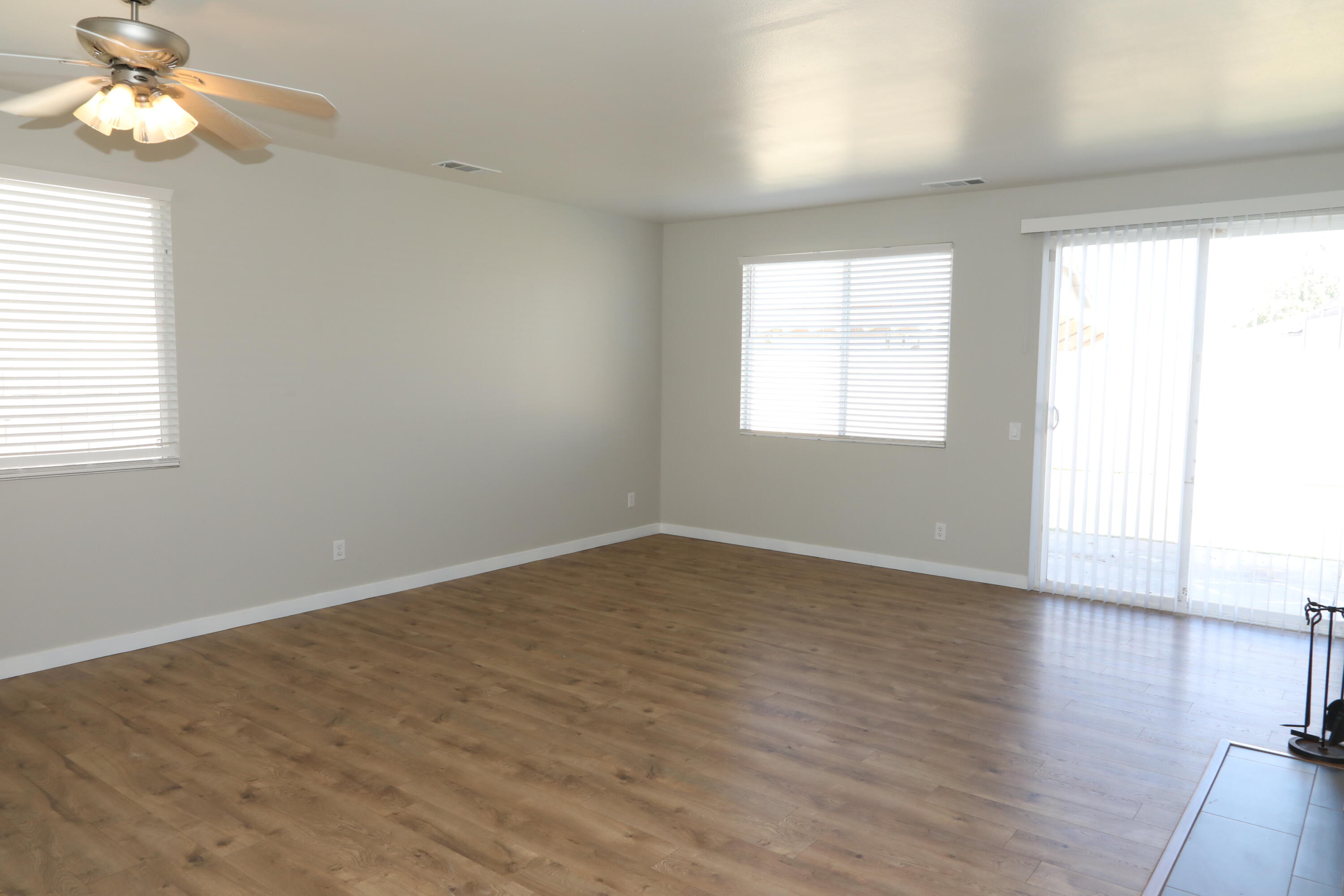 1559 Ave H4 Lancaster, CA 93534 - Photo 4 of 16 an empty room with wooden floor fan and windows
