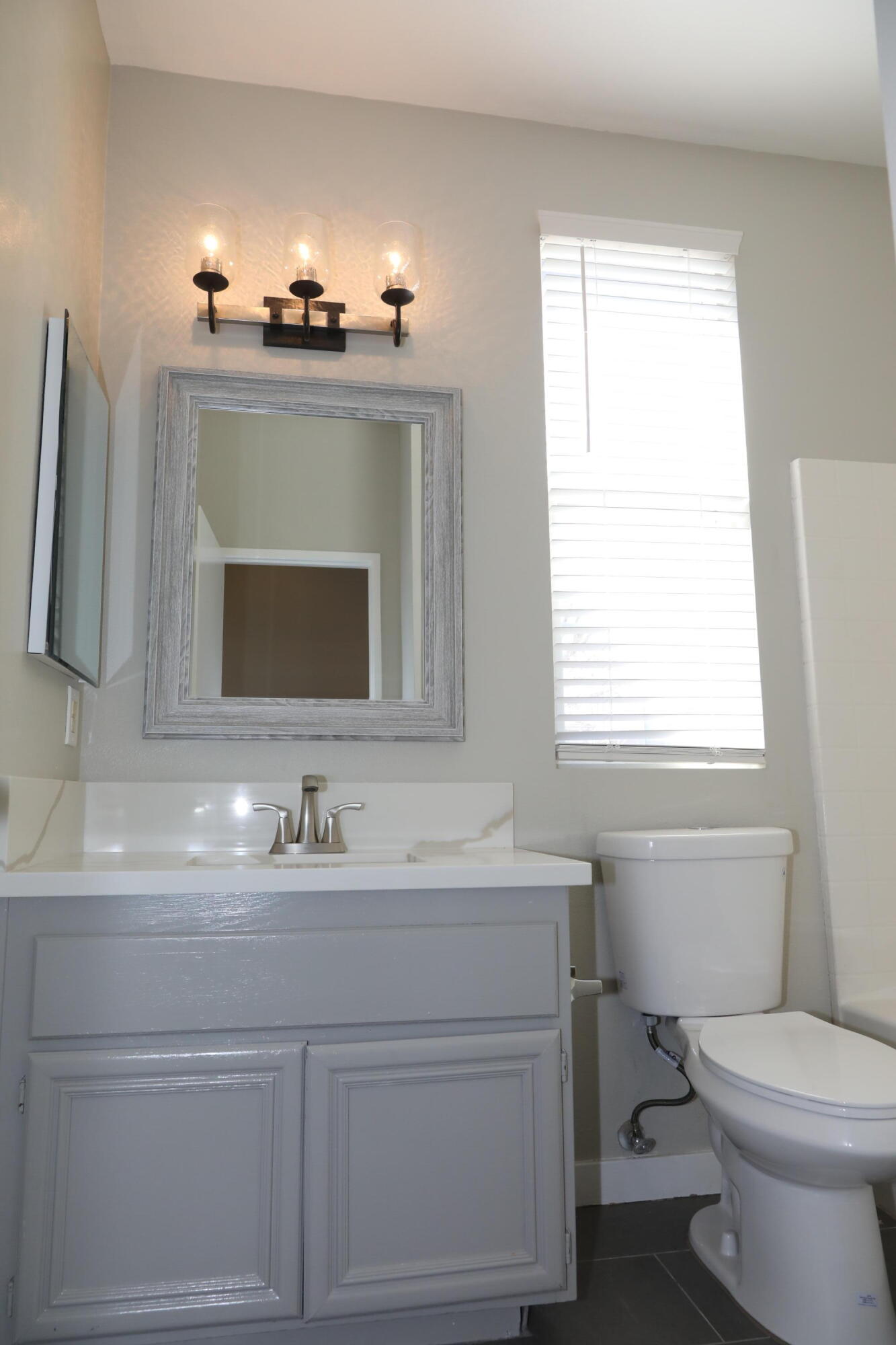 1559 Ave H4 Lancaster, CA 93534 - Photo 10 of 16 a bathroom with a sink vanity mirror and toilet