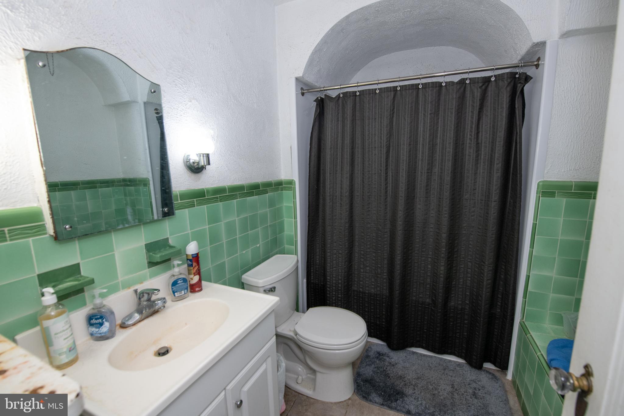 5608 Woodbine Avenue Philadelphia, PA 19131 - Photo 32 of 44 a bathroom with a sink a toilet and shower curtain