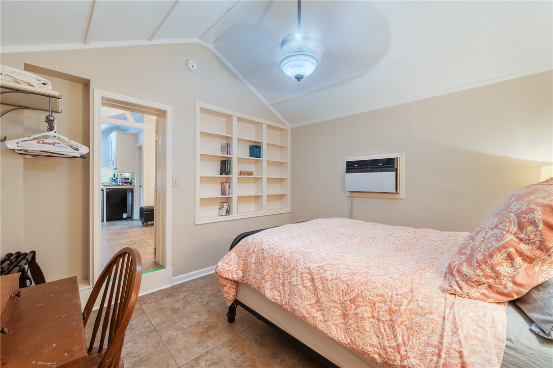 715 Inwood Drive Bryan, TX 77802 - Photo 19 of 34 a bedroom with a bed next to a window and a chandelier