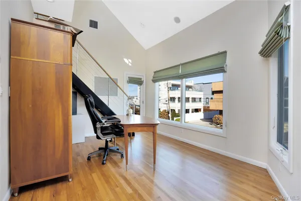 a view of a hallway with wooden floor and staircase
