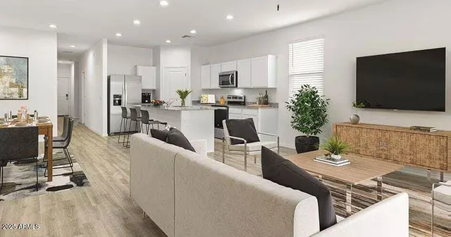 a living room with furniture a flat screen tv and kitchen view