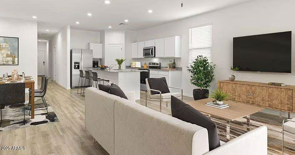 25200 North 151st Drive, Unit 5 Surprise, AZ 85387 - Photo 3 of 14 a living room with furniture a flat screen tv and kitchen view