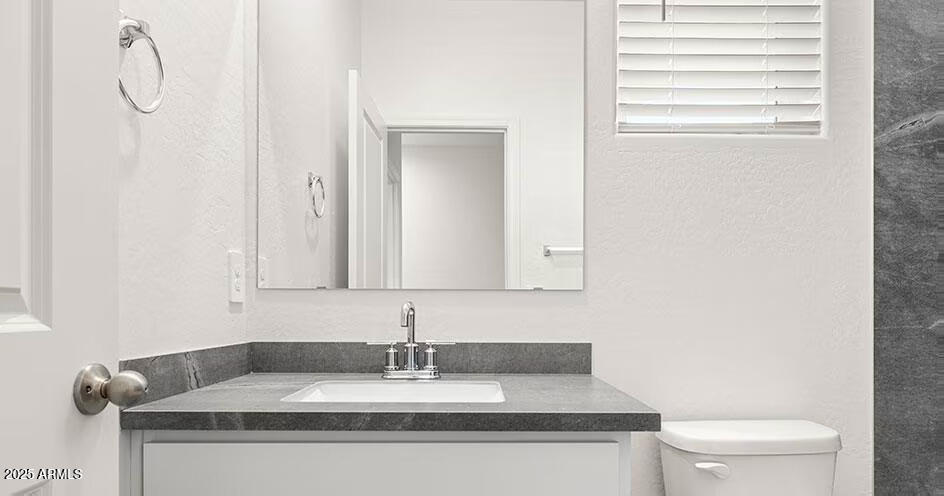 25200 North 151st Drive, Unit 5 Surprise, AZ 85387 - Photo 9 of 14 a bathroom with a granite countertop sink and a toilet
