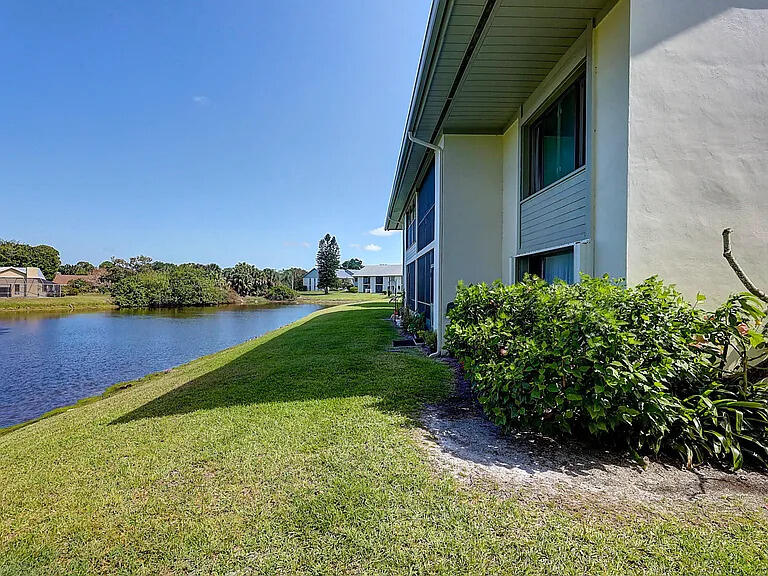 2243 Northwest 22nd Avenue, Unit 104 Stuart, FL 34994 - Photo 16 of 26 a backyard of a house with lots of green space and lake view