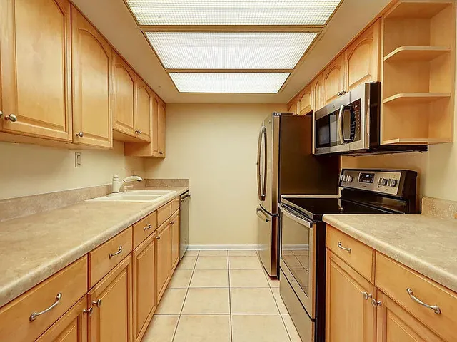 a kitchen with stainless steel appliances a sink and a refrigerator