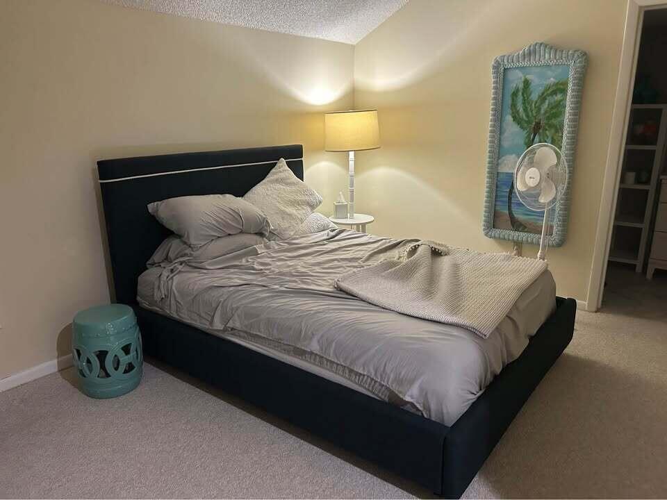 2243 Northwest 22nd Avenue, Unit 104 Stuart, FL 34994 - Photo 8 of 26 a bedroom with a bed and painting on the wall