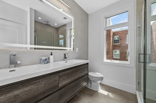 a white bed sitting in a bedroom next to a window