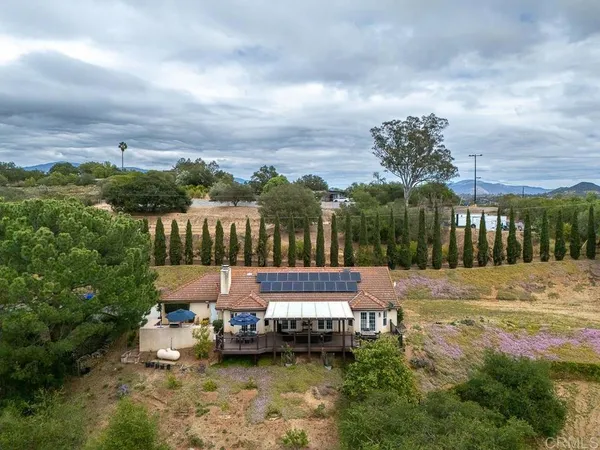an aerial view of a house with a yard and lake view
