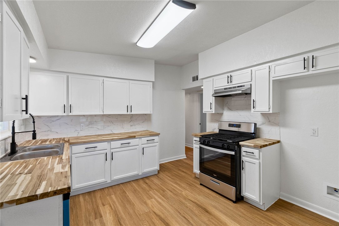 4018 Stirman Street Corpus Christi, TX 78411 - Photo 11 of 22 a kitchen with stainless steel appliances granite countertop a stove a sink and a refrigerator