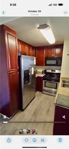 a kitchen with stainless steel appliances kitchen island granite countertop a refrigerator and a stove