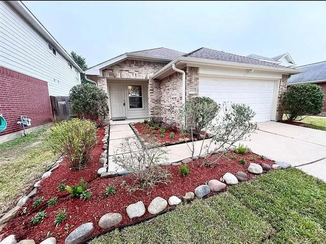 a front view of a house with a lot of flowers