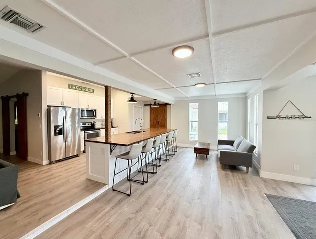 a living room with furniture a wooden floor and next to a window