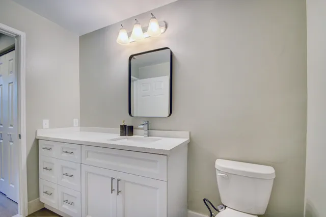 a bathroom with a toilet sink and mirror