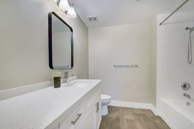 a bathroom with a sink a toilet and shower