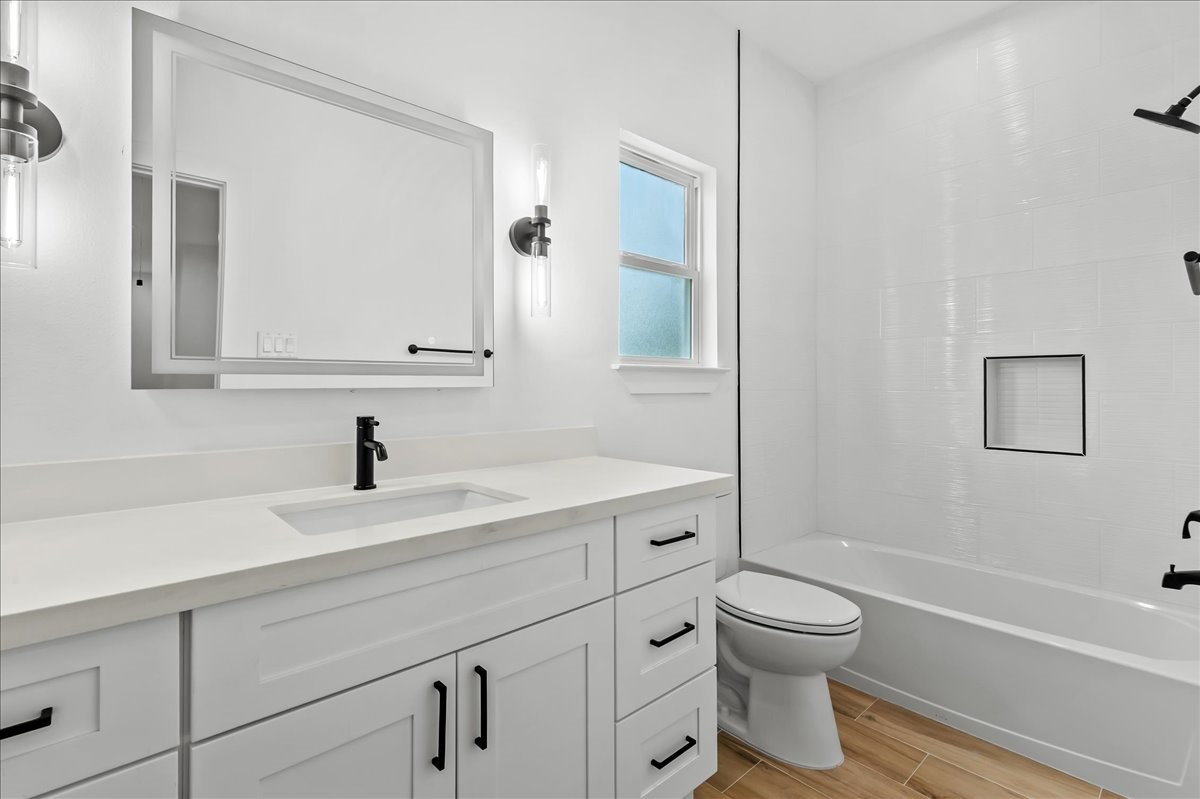 8323 Observatory Street, Unit A/B Houston, TX 77088 - Photo 30 of 38 Unit A - Secondary bathroom features a tub/shower combination accented with elegant black fixtures and a modern LED vanity mirror, creating a stylish and functional space for family and guests.
