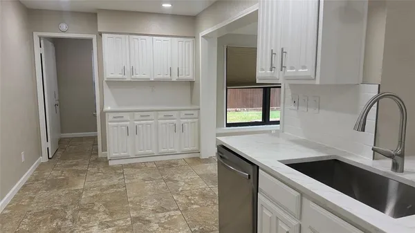 a view of a kitchen with wooden floor and a window