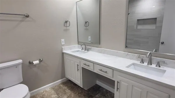 a white toilet and tub sitting next to a bathroom sink