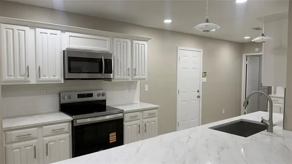 a kitchen with a sink stove and microwave
