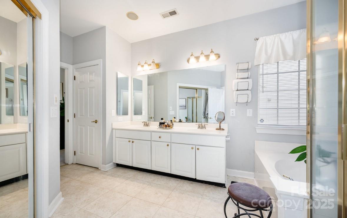 6930 Reedy Creek Road Charlotte, NC 28215 - Photo 16 of 28 a spacious bathroom with a double vanity sink and a mirror