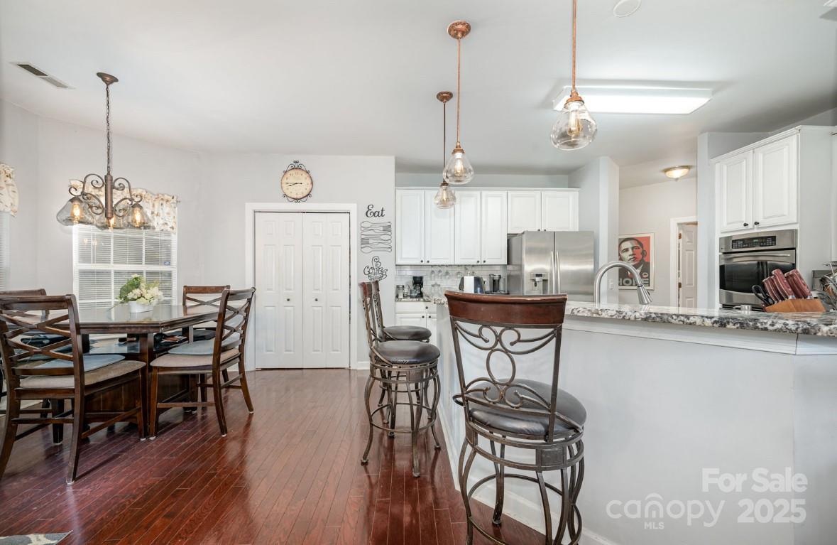 6930 Reedy Creek Road Charlotte, NC 28215 - Photo 26 of 28 a view of a dining room with furniture window and wooden floor