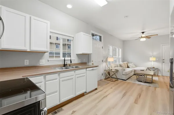 a open kitchen with stainless steel appliances granite countertop a lot of living room couch and cabinets
