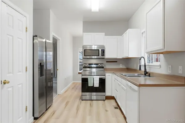a kitchen with stainless steel appliances a stove a sink and a refrigerator