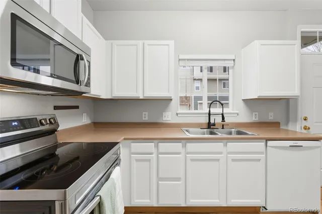 a kitchen with stainless steel appliances granite countertop a sink a stove and cabinets