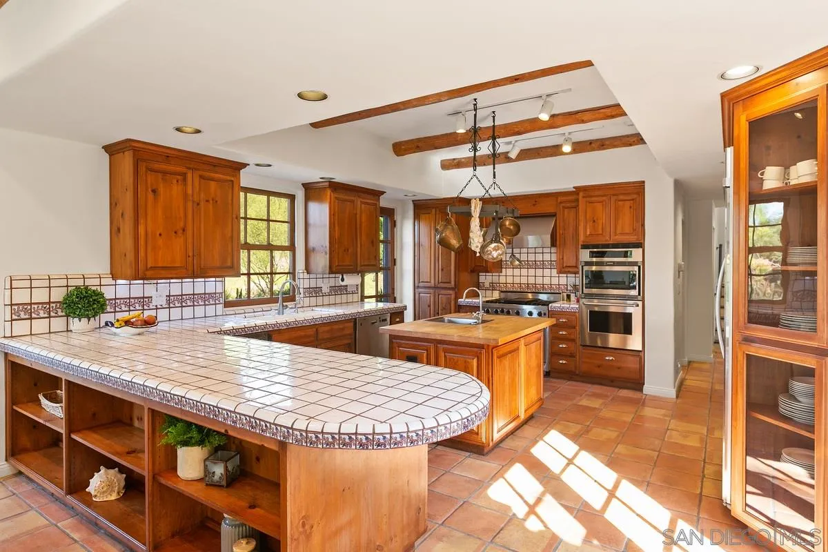 16309 Orchard Bend Road Poway, CA 92064 - Photo 14 of 66 a large kitchen with kitchen island a large counter space appliances and cabinets
