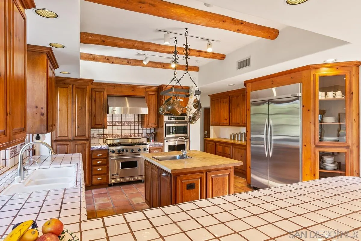 16309 Orchard Bend Road Poway, CA 92064 - Photo 15 of 66 a kitchen with stainless steel appliances kitchen island granite countertop a stove and a wooden cabinets