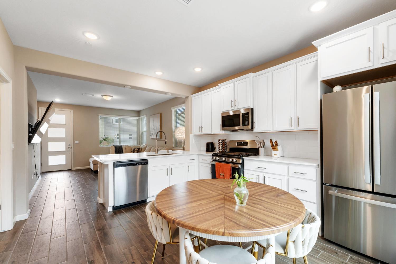 1106 Significant Way West Madera, CA 93636 - Photo 16 of 41 a kitchen with stainless steel appliances granite countertop a refrigerator a stove top oven a sink dishwasher and white cabinets with wooden floor