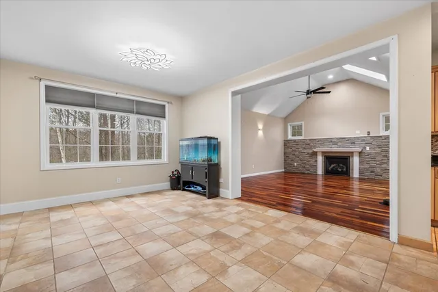 a view of empty room with fireplace and windows