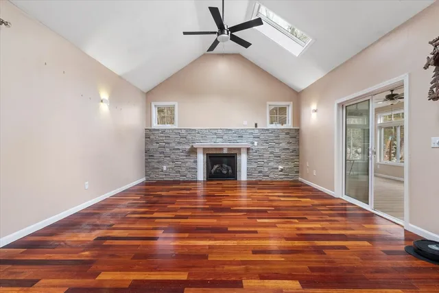 a view of empty room with wooden floor and fireplace