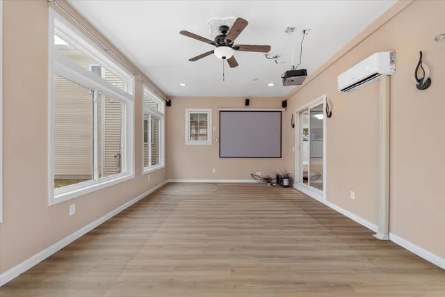 a view of empty room with wooden floor and ceiling fan