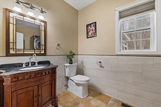 a bathroom with a toilet a sink and mirror