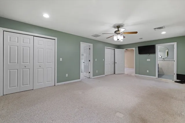 a view of empty room with a ceiling fan and window