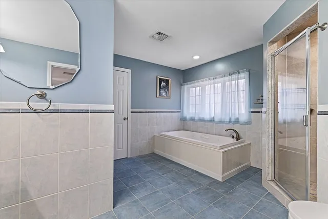 a bathroom with a tub a window and a shower