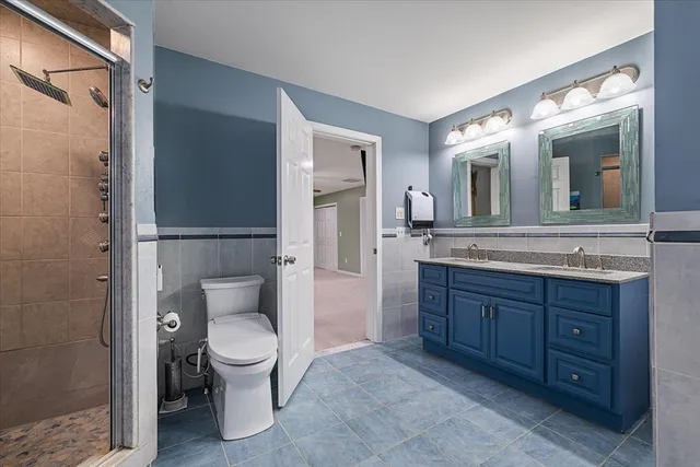 a spacious bathroom with a granite countertop toilet sink and a mirror
