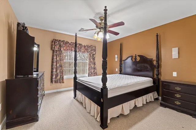 a spacious bedroom with a bed and a chandelier