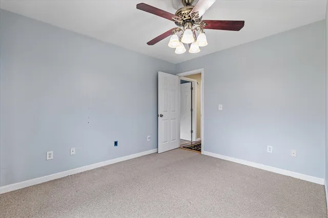 an empty room with a chandelier fan